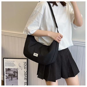Minimalist black nylon crescent shoulder bag featuring adjustable strap for casual wear