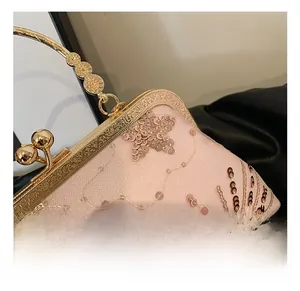 Close-up of pink sequined evening bag with vintage gold engraved metal frame and clasp