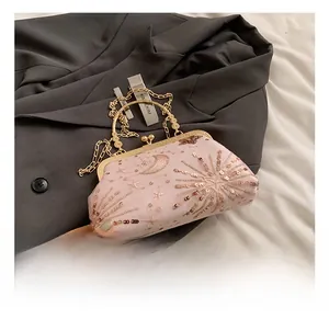 Detail of pink sequin clutch with moon embroidery and golden chain shoulder strap