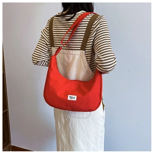 Red nylon crescent shoulder bag for women with adjustable strap and logo patch