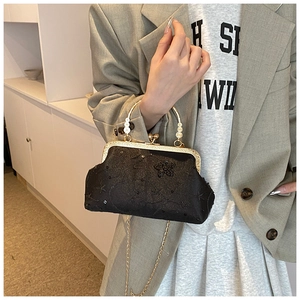 Detail of vintage black shell bag featuring sequins and butterfly embroidery with chain