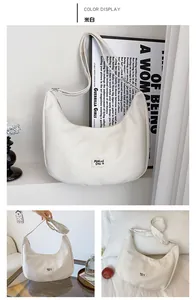 Detail of off-white hobo bag with Malui Dsi logo and zipper in home setting