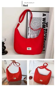 Detail view of red waterproof nylon crescent bag with adjustable shoulder strap and logo