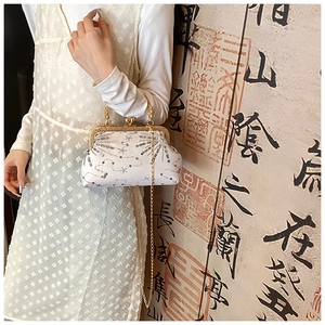Dettaglio dell'elegante borsa da sera in raso bianco con paillettes e catena d'oro