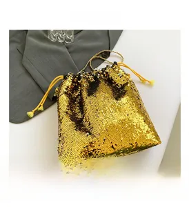 Detailed view of the gold sequined bucket bag with drawstring closure and tassel detail