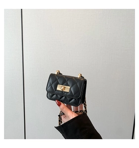 Detail of black quilted leather mini bag with gold twist lock and chain strap