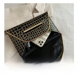 Details der Clutch mit Kroko-Prägung, Goldbesatz und Platz für ein Smartphone