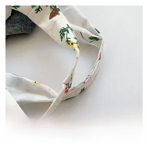 Detailed shot of white fabric shoulder strap with floral embroidery and denim lining