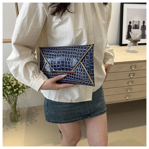 Dunkelblaue Umschlag-Clutch mit goldener Krokostruktur und Metallsteg-Detail