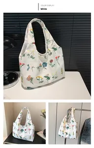 Detail view of white floral tote bag with colorful flower patterns and wide shoulder straps