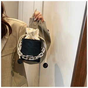 Close-up of black leather bucket bag with rich rabbit embossing and silver chain