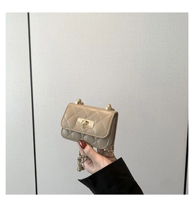 Close-up of beige quilted leather mini bag featuring gold twist lock and chain strap