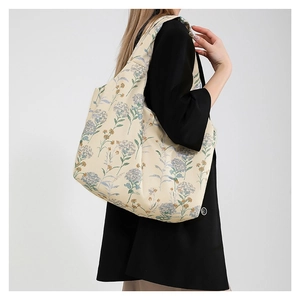 Floral canvas tote bag with blue hydrangea prints shown on model for a casual look
