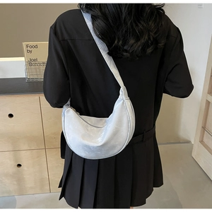 Borsa a mezzaluna in morbida pelle PU grigio chiaro vista di lato su una modella
