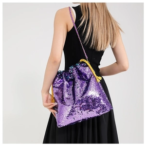 Purple sequin bucket bag with yellow drawstring and chain strap shown on a model