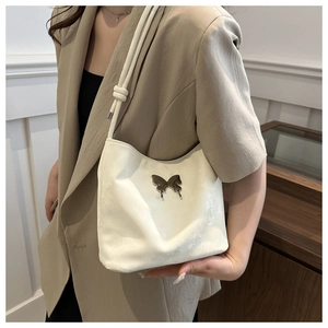 Sac seau blanc minimaliste chic avec détail papillon argenté et bandoulière tissée