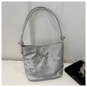 Détail du sac seau argenté avec boucle papillon métallique et texture scintillante