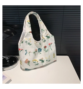 Détail d'un sac cabas en toile blanche avec imprimés floraux vifs et design minimaliste