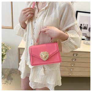 Sac bandoulière rose avec boucle cœur dorée ornée de perles et bandoulière chaîne