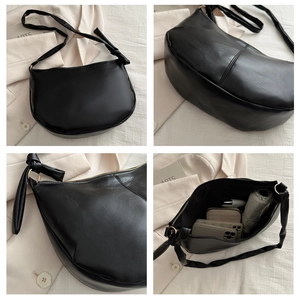Detail view of black hobo bag showing large capacity, soft texture and wide strap