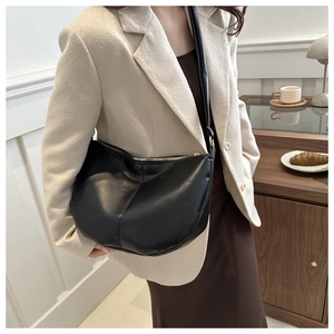 Detail of a large black soft PU leather hobo bag with gold zipper and shoulder strap