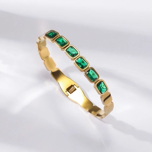 Gold plated stainless steel bracelet featuring six emerald-cut green gemstones