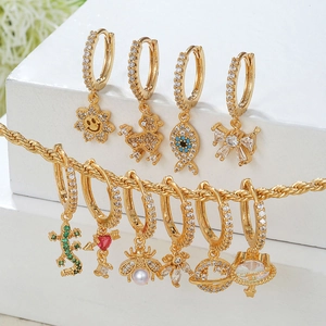 Détail de créoles dorées 18 carats avec pavé de zircons et divers pendentifs variés