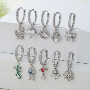 Lot de dix créoles plaquées or 18 carats avec pendentifs en zircon sur présentoir