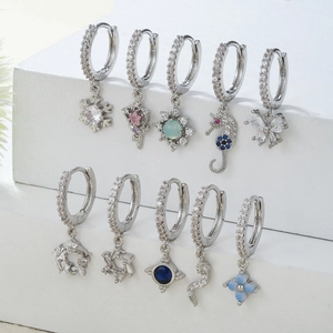 Dettaglio del set di orecchini color argento con zirconi colorati e ciondoli a cuore