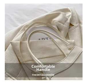 Detail of comfortable off-white faux leather handbag handle on textured blazer