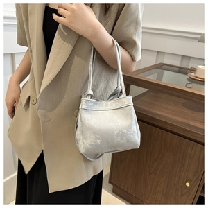 Detail view of stylish silver bucket bag featuring unique snowflake metallic texture