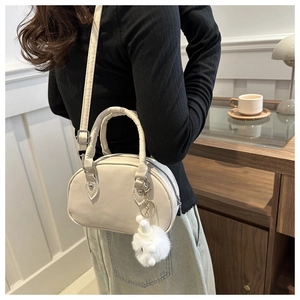Mini Retro-Bowlingtasche in Creme mit Plüsch-Anhänger in wohnlichem Lifestyle-Ambiente