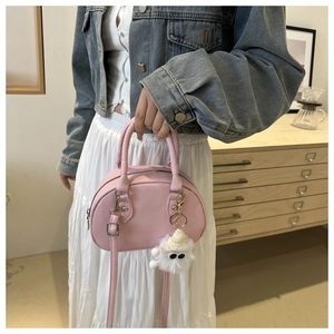 Detailansicht der rosa halbrunden PU-Lederhandtasche mit weißem Plüsch-Anhänger