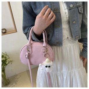 Rosa Mini-Bowlingtasche als Umhängetasche mit Jeansjacke und Plüsch-Anhänger