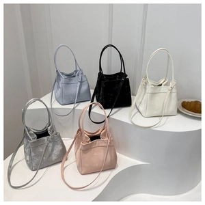Minimalist velvet bucket bags in five colors displayed on tiered white stands