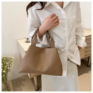 Bolso tote marrón con estampado de cocodrilo llevado por modelo en estilo minimal
