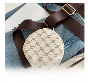 Detail of round vintage check coin purse with adjustable wide brown nylon shoulder strap