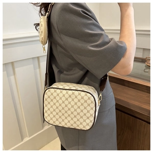Detail view of plaid monogram crossbody bag with small hanging coin purse on shoulder strap