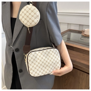 Detail of monogram camera bag with round coin purse and adjustable wide strap