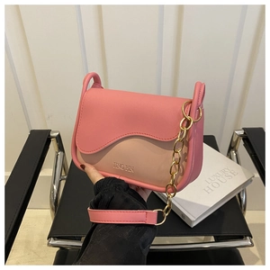 Close-up of pink and beige patchwork leather crossbody bag with gold chain strap