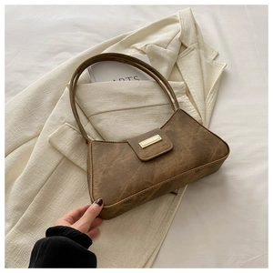 Vintage brown leather shoulder bag with gold buckle on white blazer for women