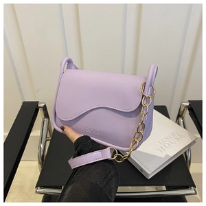 Detail of lavender PU leather crossbody bag with wave flap and gold chain strap