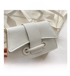 Close-up of white lychee pattern leather handbag with flap buckle and gold hardware