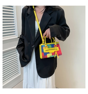 Detail of colorful patchwork crossbody bag featuring red blue and yellow panels with tassels