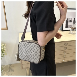 Detailed close-up of a vintage checkered crossbody bag with round coin purse and wide strap