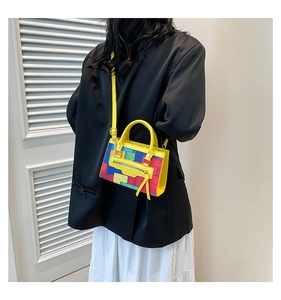 Detail of colorful geometric checkered handbag with yellow tassel on a fashion model
