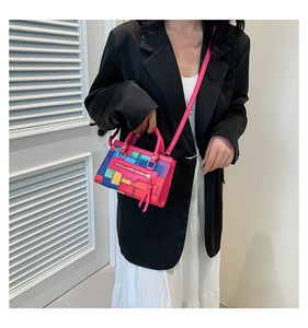 Detail of colorful geometric block pattern and golden zipper on this mini square bag