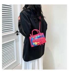Detail of colorful geometric patchwork handbag with fringe and detachable strap