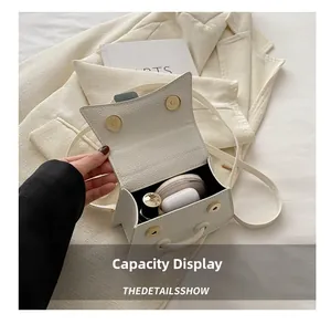 Internal capacity view of white pebble leather mini bag with lipstick and earphones