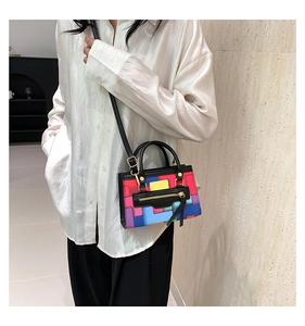 Detail of colorful patchwork crossbody bag with black handle and gold hardware components